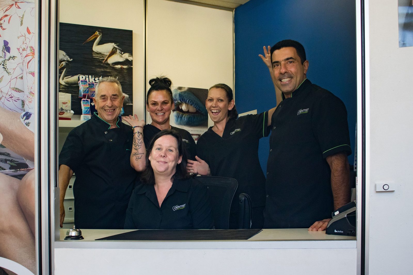 The Dentist on Waverley team smiling behind the reception desk